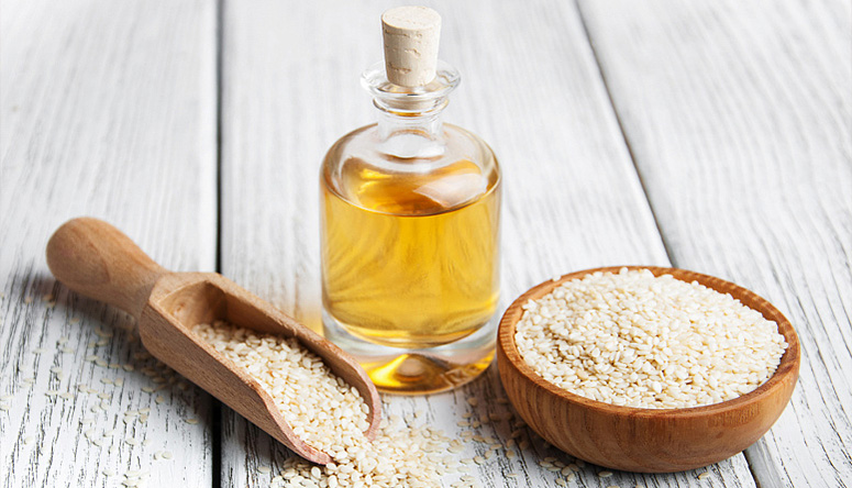 .Photo of golden sesame oil resting on a wooden table for Ayurvedic joint treatment