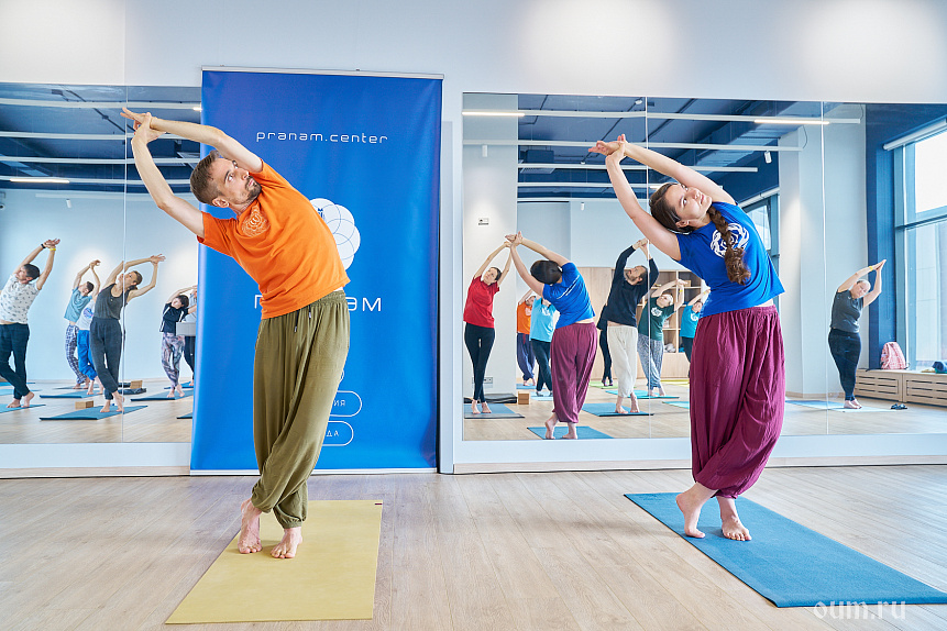 Photo of a yoga instructor leading a group side stretch to improve biomechanics