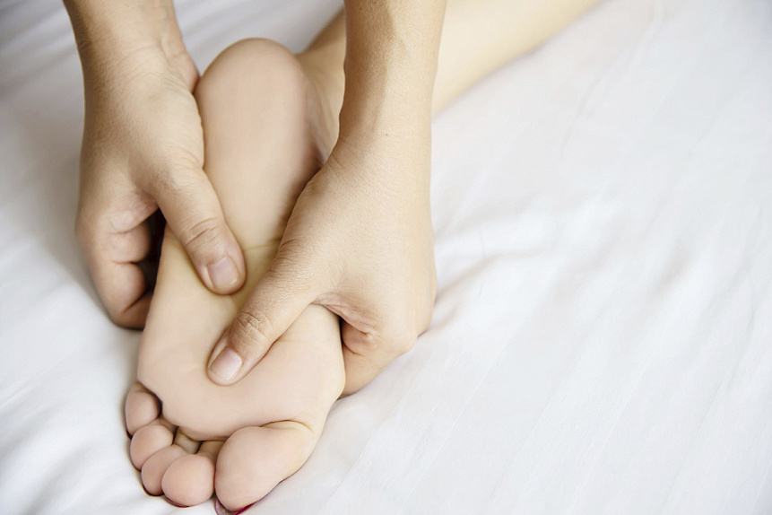 Photo of hands gently massaging the sole of a foot to release muscle tension and promote relaxation.