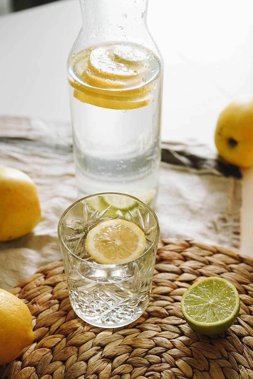 Glass of warm water with fresh lemon slices on a wooden table highlighting Ayurvedic methods for better digestion