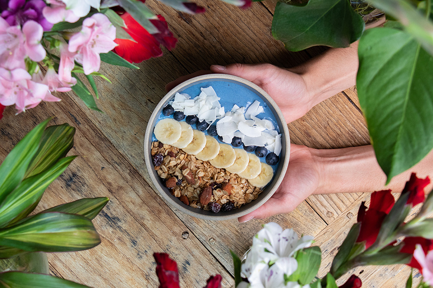 Photo of a nutritious smoothie bowl in a person's hands visualizing scientific interest in the impact of nutrition on long-term health