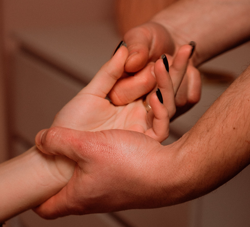 Photo of a practitioner's hands applying warm herbal oil for detoxification during an Ayurvedic Abhyanga massage.