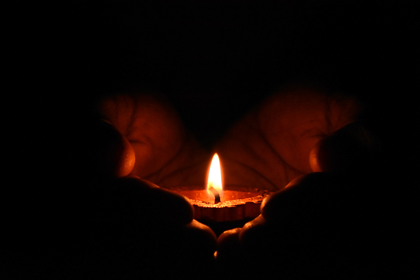 Close-up of hands gently holding a flame illustrating conscious control over internal energy and emotional state