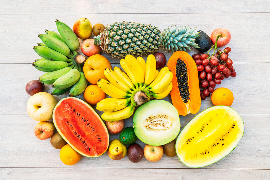 Photo of fresh tropical fruits on a wooden table, representing a nourishing diet for reproductive health.