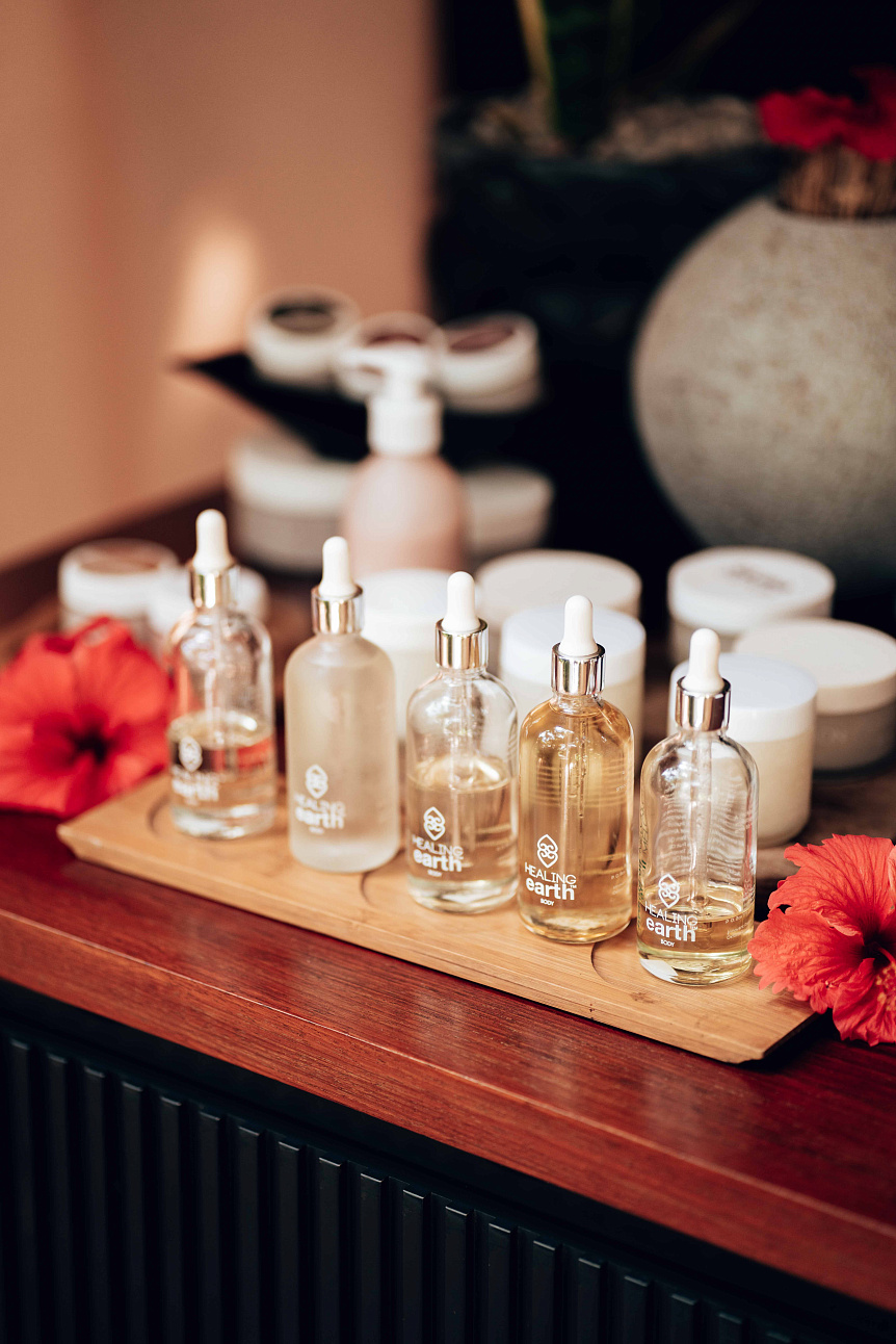 Photograph of base oil bottles and ubtan powder resting on a woven mat before starting a home spa treatment.