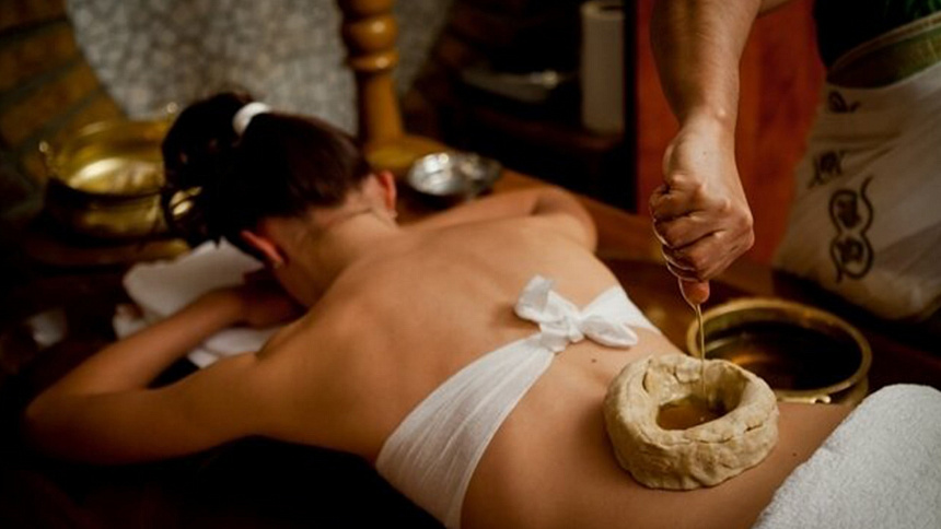 Photo of a therapist's hands shaping a dough barrier on a patient's back for deep tissue heating