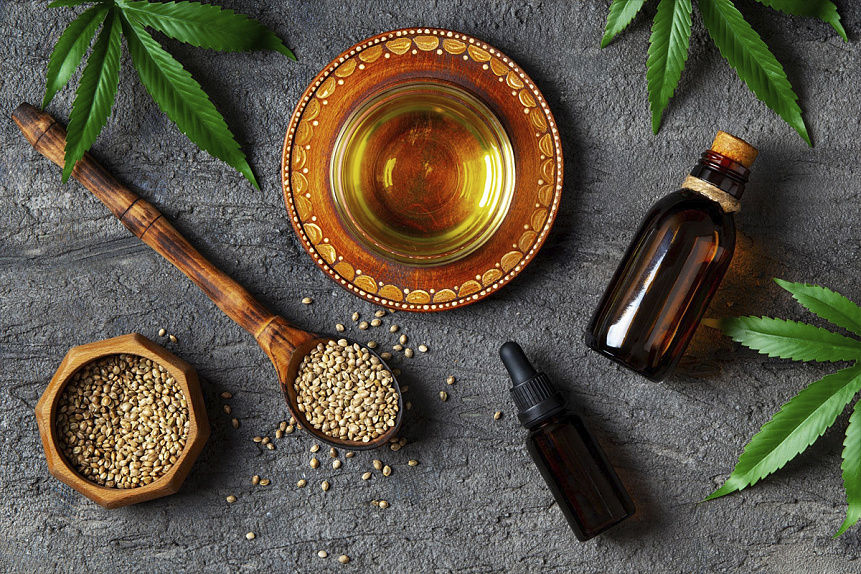 Photo of a ceramic bowl with oil and natural botanical seeds preparing for an Ayurvedic foot massage.
