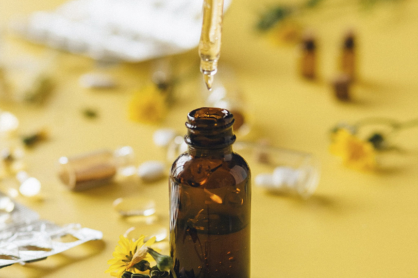 Photo of an amber dropper bottle dripping natural oil representing traditional Ayurvedic nasya self-care ritual