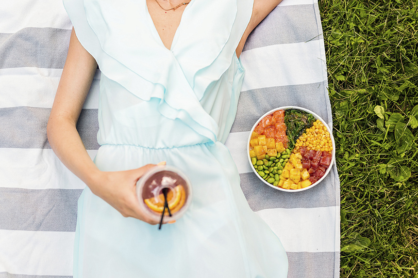 Photograph of a resting young woman with a healthy poke bowl illustrating a return to natural biorhythms